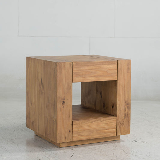 The Harlan End Table in oak features a modern square design with an open middle shelf and solid side and top panels, shown on a light floor against a white wall.