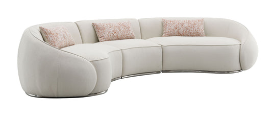 The Sahara - Boucle Sectional Sofa With 3 Pillows in beige features a curved, modern design and chrome base, complemented by three accent pillows, set against a white background.