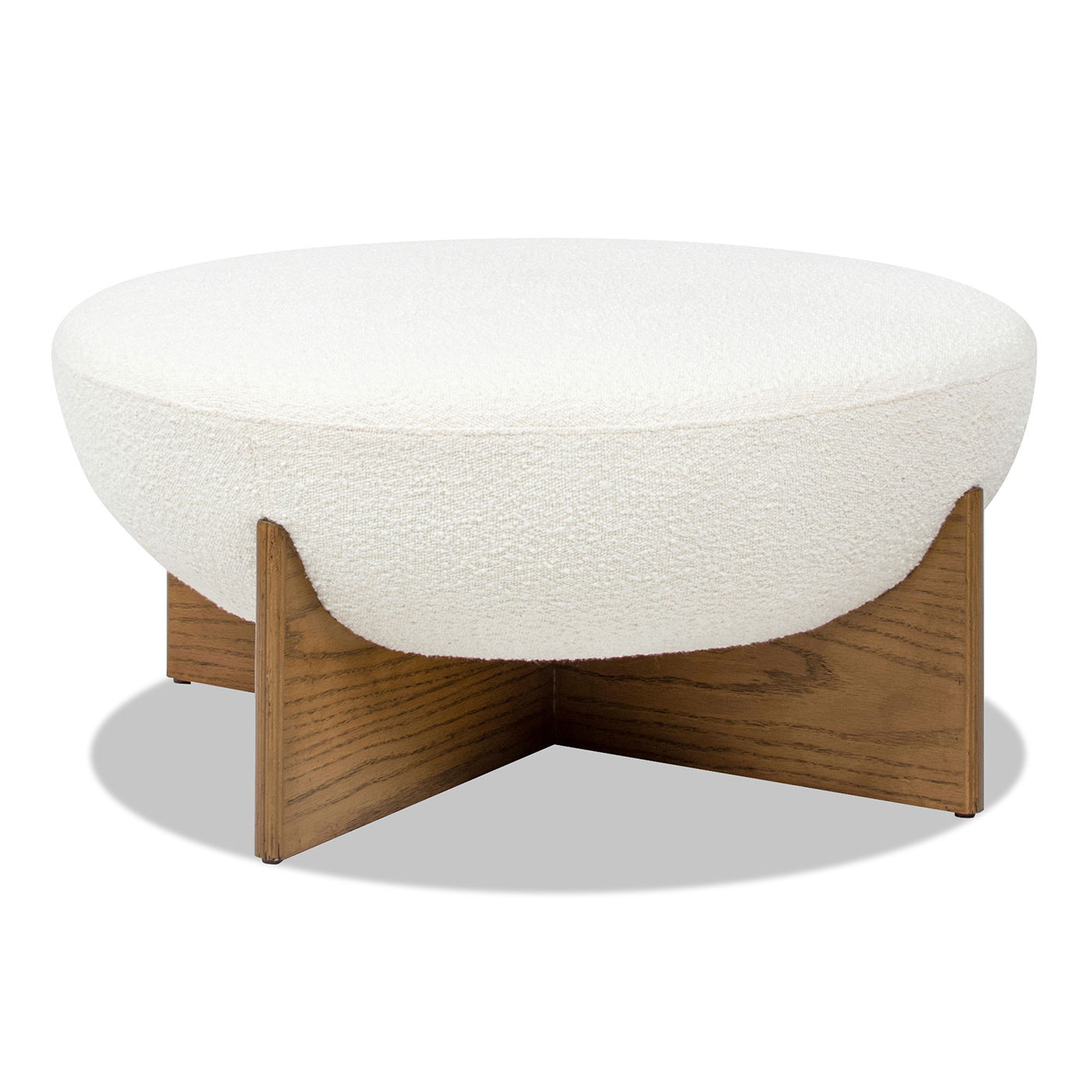 The Bali - Round Upholstered Ottoman features a white, textured cushion with a thick top, resting on a sturdy, medium-toned wooden X-shaped base for even support.