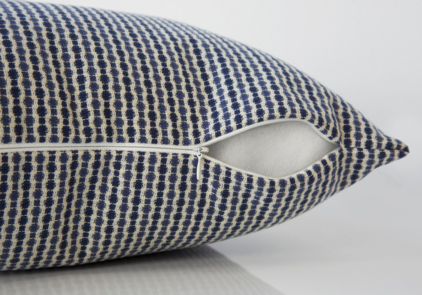 Close-up of the Square Decorative Throw Pillow, blue and white patterned, with a partially open white zipper showing the hypoallergenic insert. The background is plain and light-colored. Insert included.