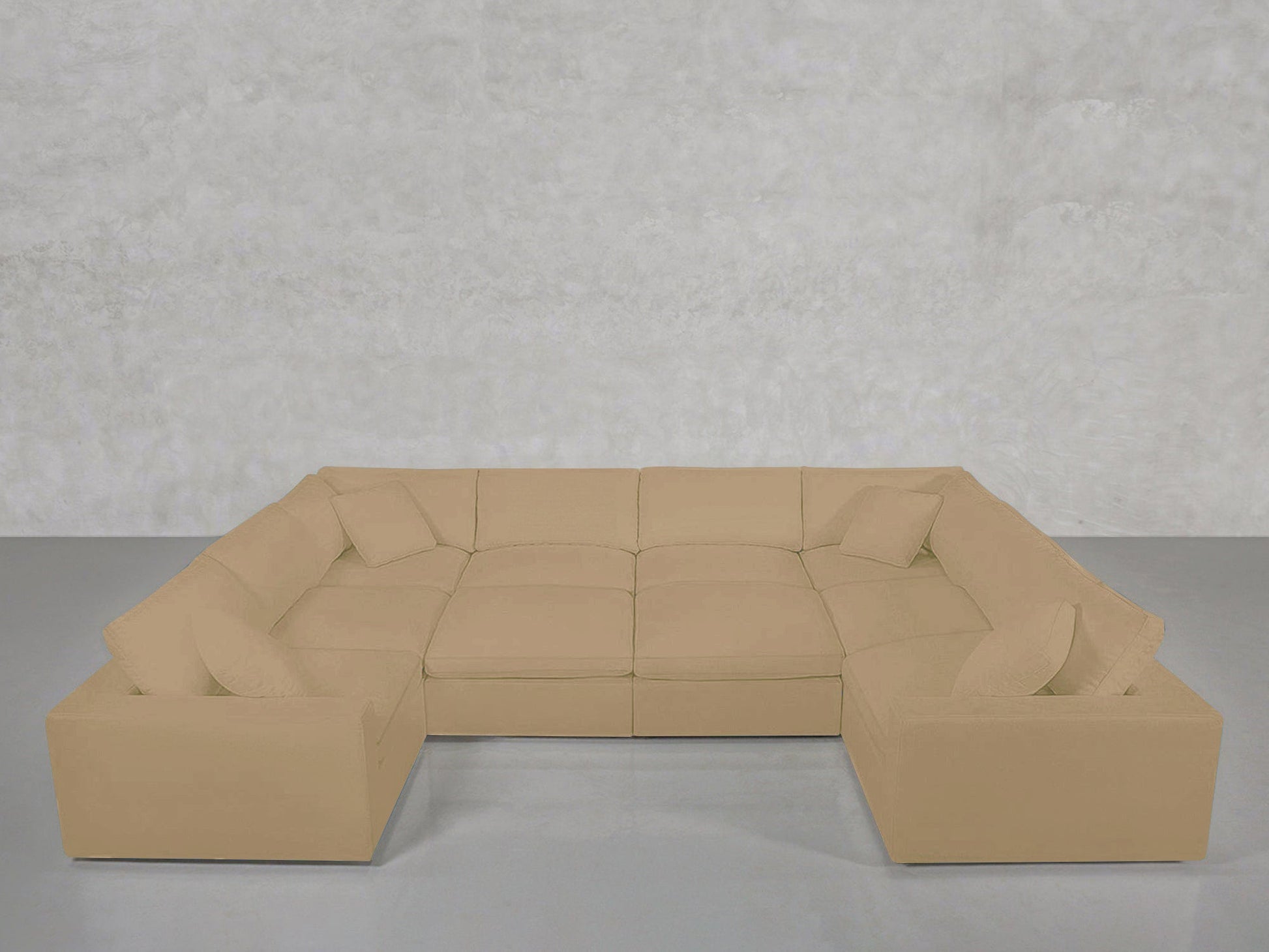 A spacious beige 10-Seat Modular Closed Pit sectional with matching cushions is arranged on a gray floor against a plain, light gray textured wall.