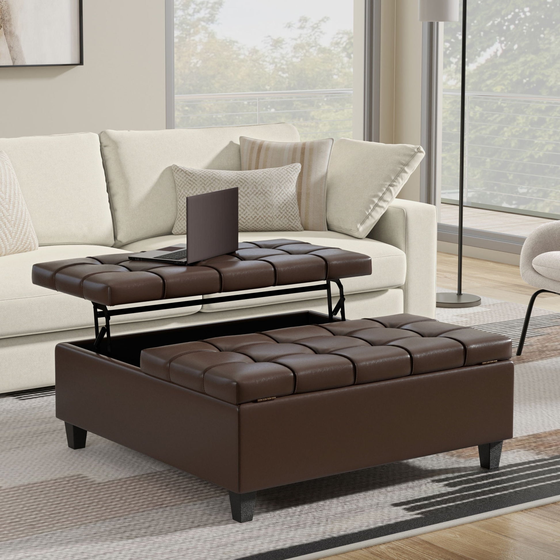 A modern living room showcases a beige sofa and the Harrison - Upholstered Coffee Table Storage Ottoman with a lift-top tray for hidden storage, complemented by large windows and neutral decor.