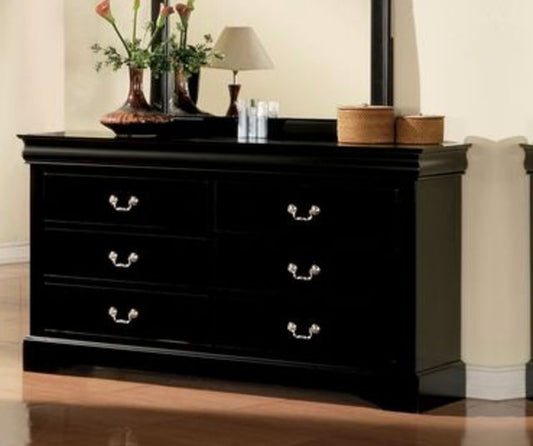 The Louis Philippe III dresser features six drawers, silver handles, and a glossy black finish. Decorative vases with flowers, a lamp, small bottles, and two woven baskets sit on top. The dresser stands on a wooden floor.