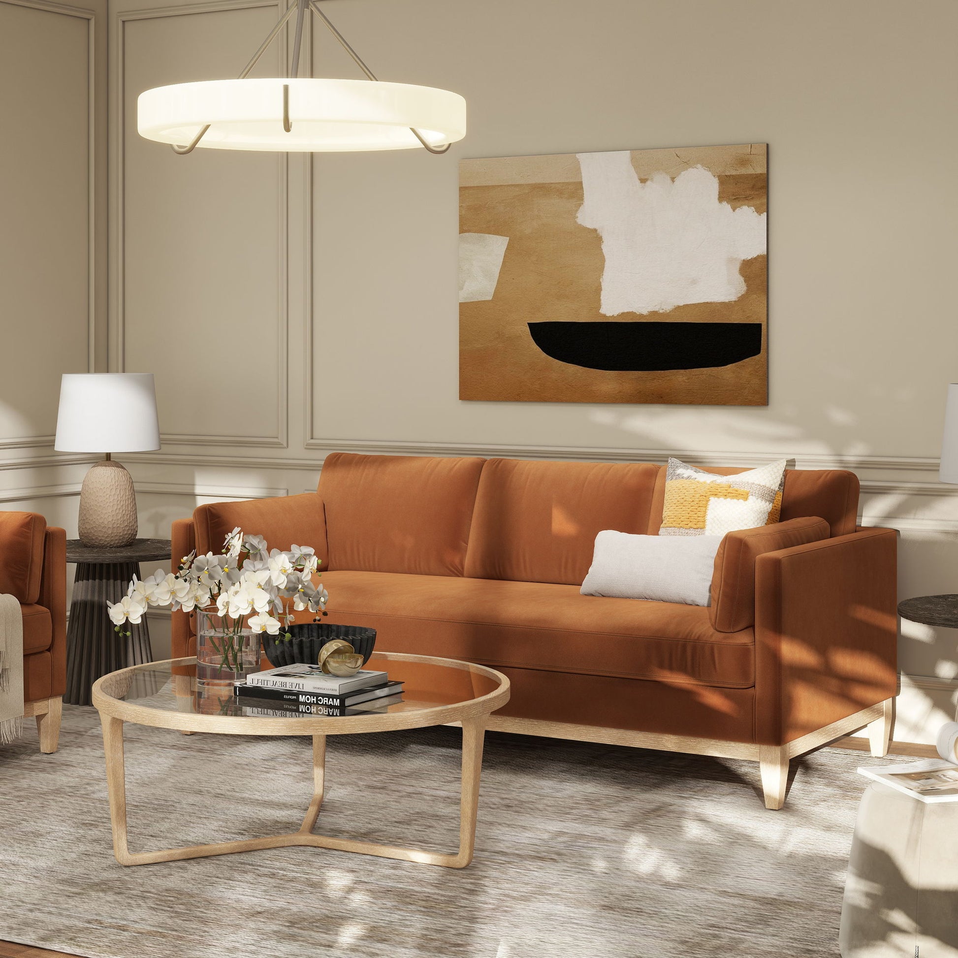 A modern living room featuring the Knox - Modern Farmhouse Sofa in rust, abstract wall art, a glass coffee table with books and flowers, two table lamps, neutral-toned decor, and soft natural light creating a cozy atmosphere.