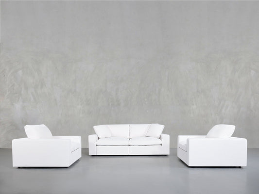 Minimalist scene featuring the 2-1-1 Sofa & Armchair Set with a white sofa and two matching white armchairs in a U-shape against a plain light gray wall and floor.