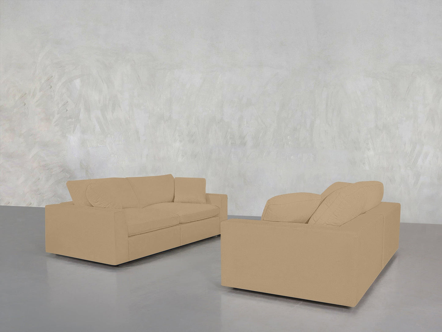 The 2-2 Sofa Set in beige is arranged facing each other on a smooth gray floor, set against a textured light gray wall for a minimalist, modern look.