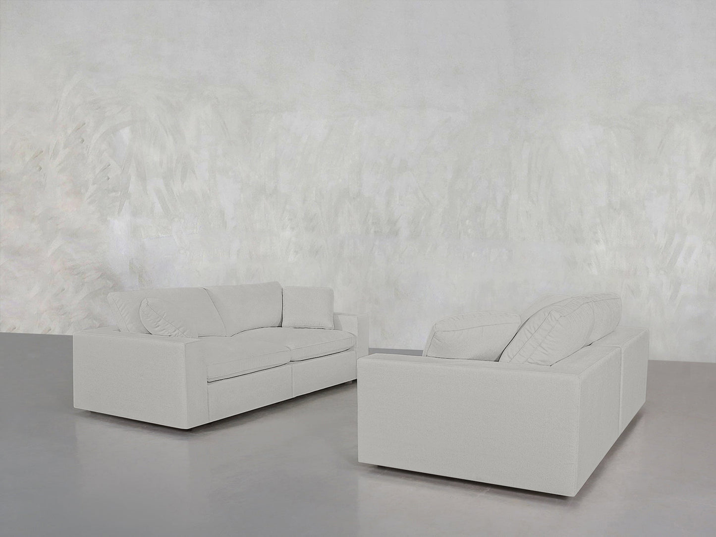 The minimalist room features a 2-2 Sofa Set in light gray, with two modern sofas facing each other against a matching textured wall and glossy gray floor. The space is empty except for the sofa set.