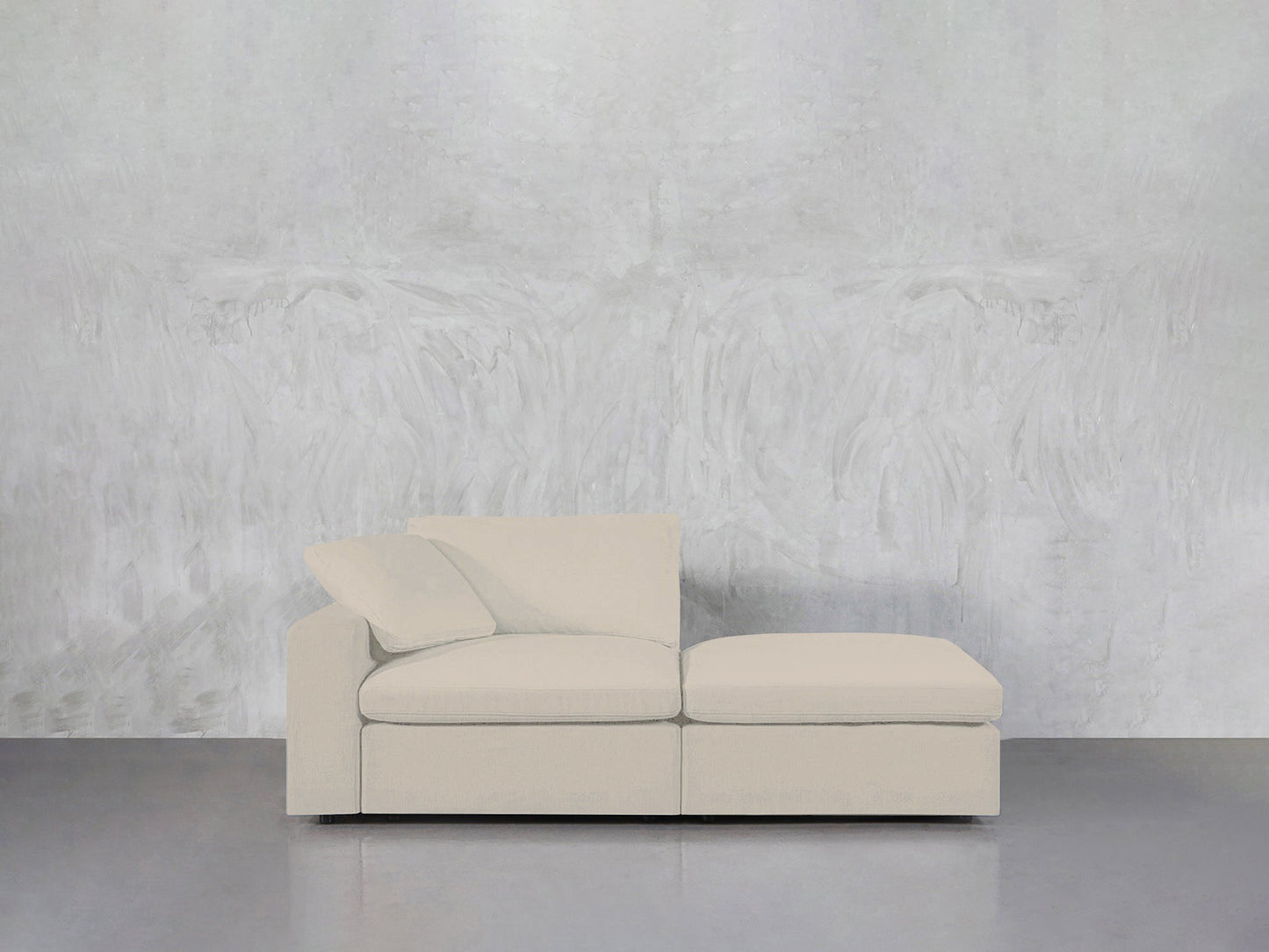 A modern 2-Seat Modular Lounger Loveseat in light beige with a left armrest is placed against a textured light gray wall on a smooth gray floor.