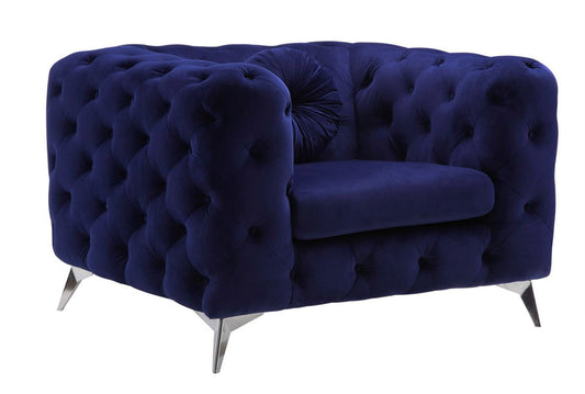 The Atronia Chair features elegant design with deep blue tufted velvet, a plush seat cushion, and metallic angled legs, displayed against a white background.