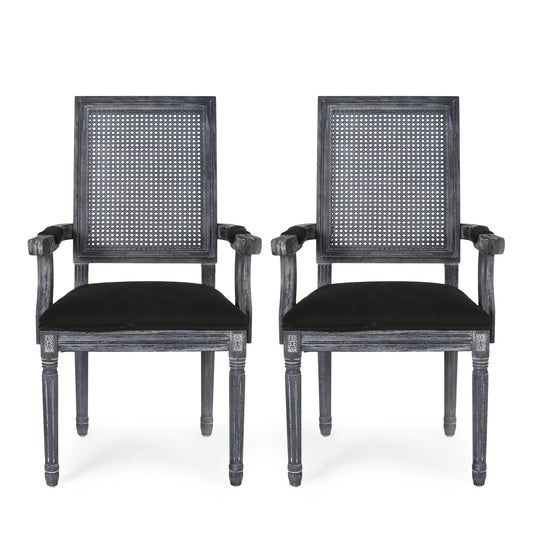 Two Elegant French Country Style Dining Chairs with black cushioned seats and cane backrests are placed side by side. The wood features a distressed black finish, accentuating the carved details on the arms and legs.