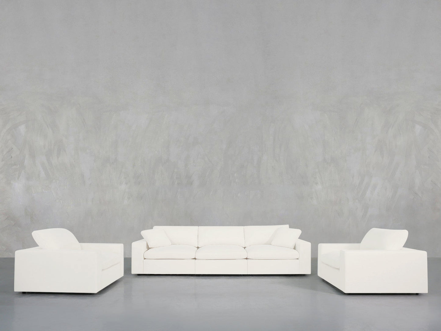 The 3-1-1 Sofa & Armchair Set is arranged in a minimalist space with a light gray textured wall and gray floor, offering a clean and modern look.