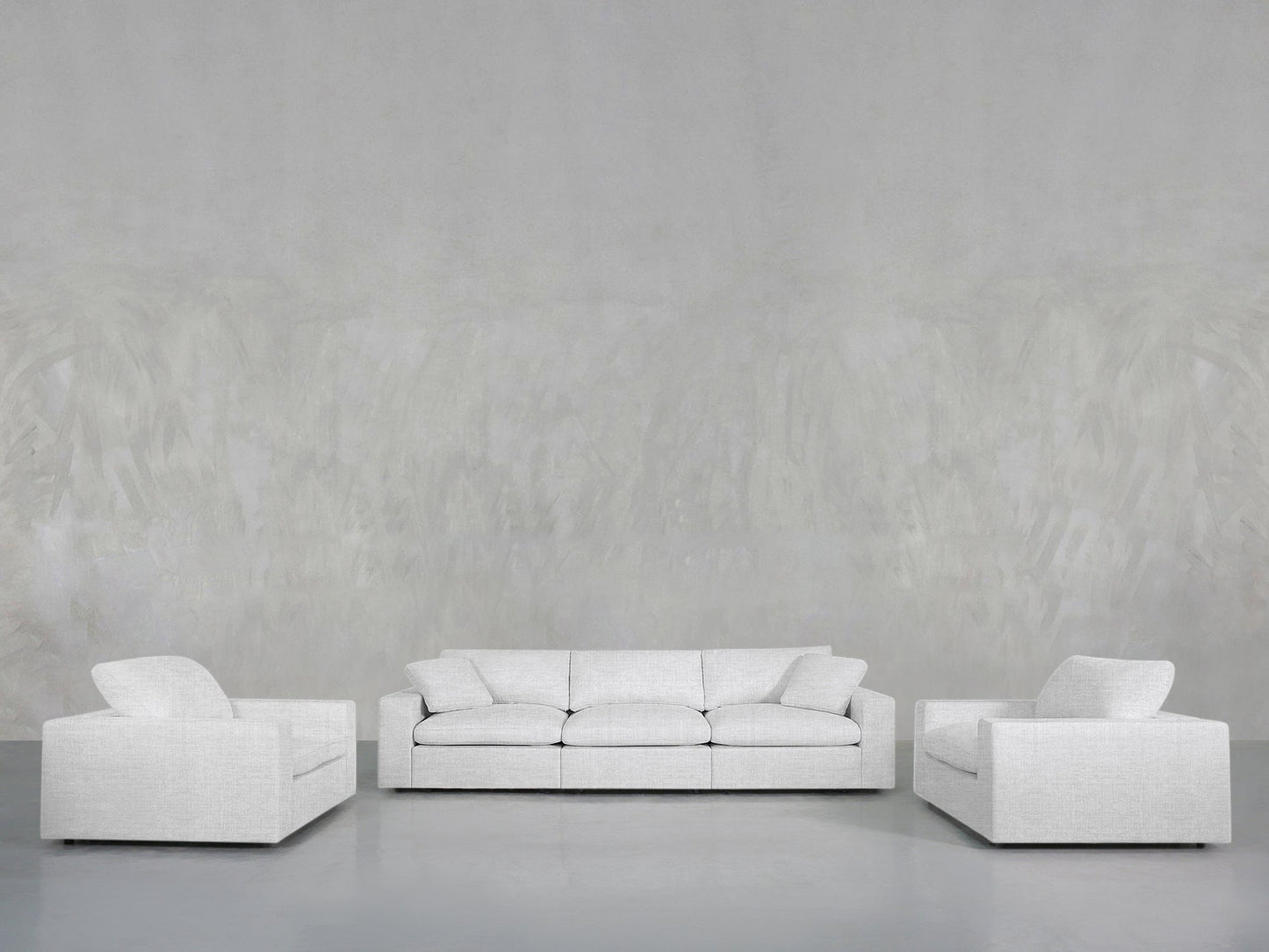 A minimalist living room setup with the 3-1-1 Sofa & Armchair Set in light gray, featuring a three-seater sofa between two matching armchairs, all against plain light gray textured walls and floor.
