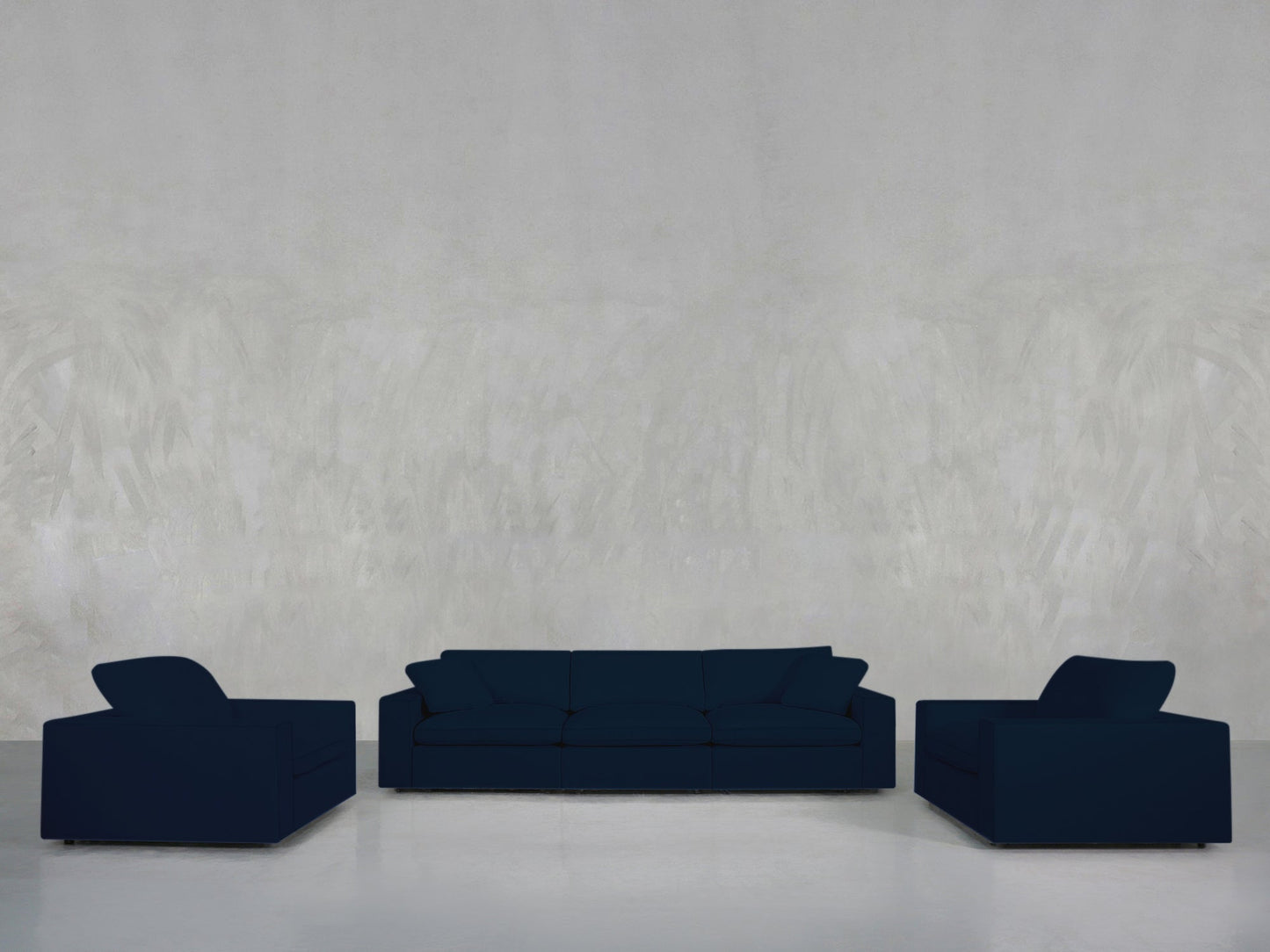 A minimalist room features the 3-1-1 Sofa & Armchair Set in navy blue, including a three-seater sofa and two matching armchairs, against a light gray textured wall and polished white floor.