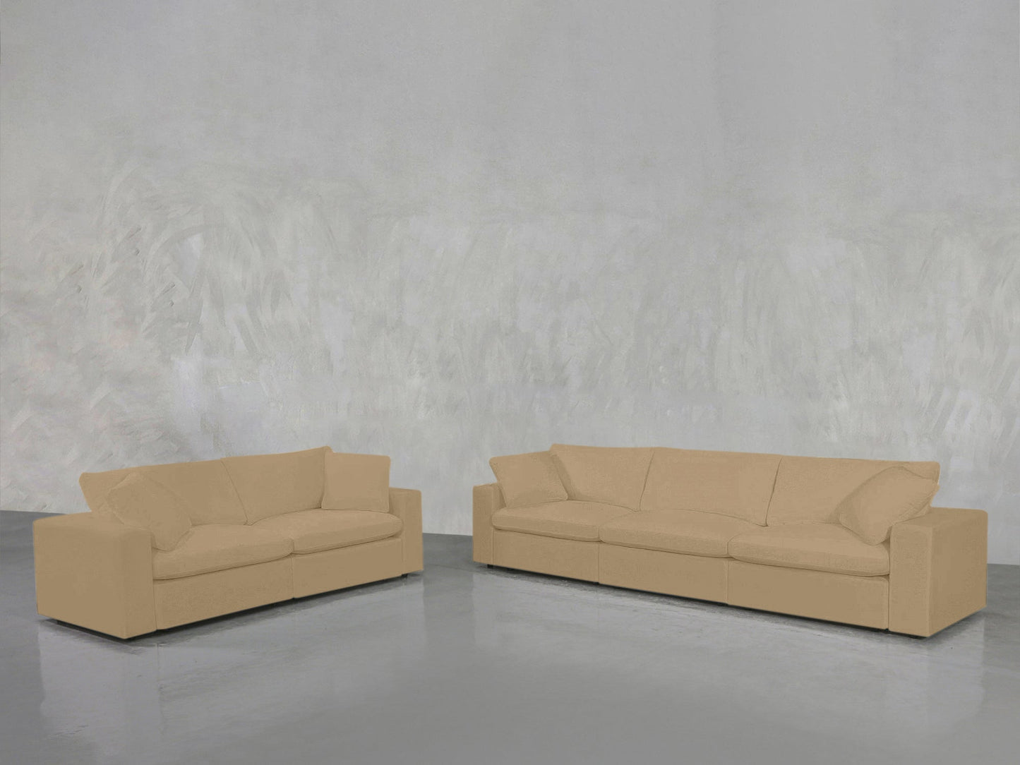 The 3-2 Sofa Set, featuring larger and smaller beige sofas, sits on a shiny gray floor by a light gray textured wall in a minimalist, empty room.