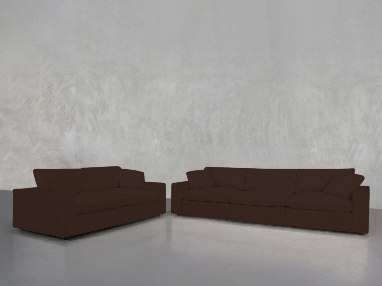 A 3-2 Sofa Set in dark brown is arranged against a plain, light gray textured wall on a shiny, light gray floor, creating a minimal and uncluttered setting.