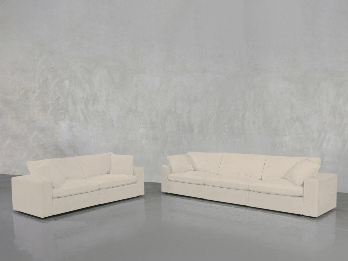 A 3-2 Sofa Set with modern design, white upholstery, and plush cushions sits on a polished grey floor against a textured light grey wall.
