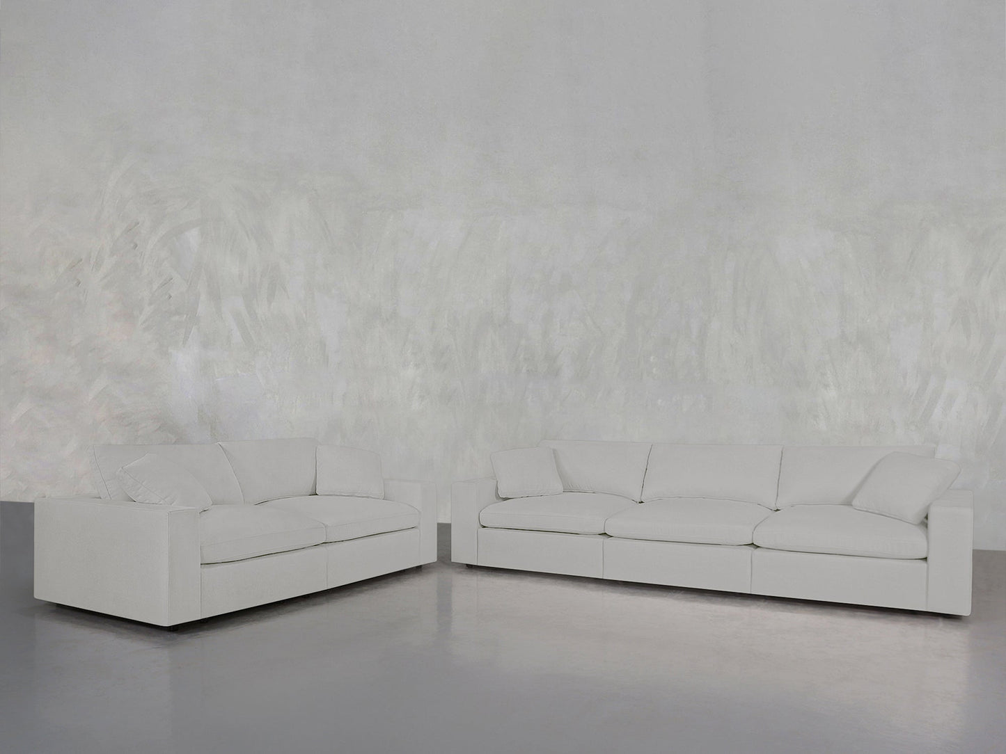 The 3-2 Sofa Set in modern white is arranged against a textured light gray wall on a smooth gray floor, creating a minimalist and spacious living room ambiance.