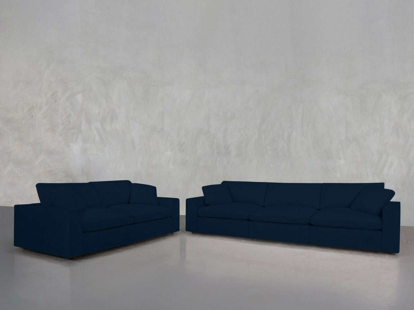 A 3-2 Sofa Set in dark blue sits against a light gray textured wall on a shiny gray floor in an empty room.