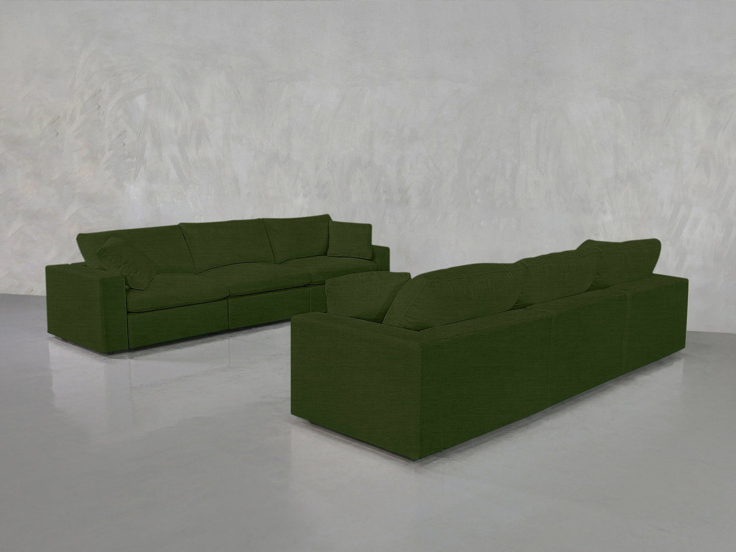 Two 3-3 Sofa Sets in olive green are arranged at angles in a minimalistic room featuring light gray textured walls and a reflective gray floor.