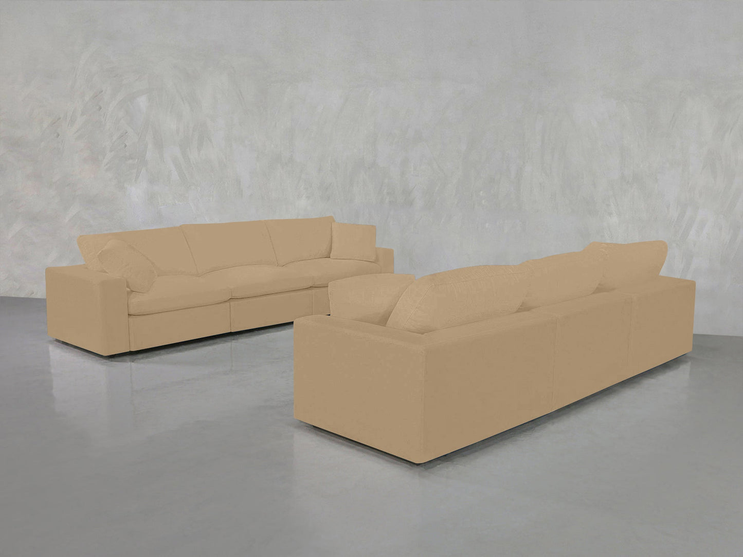 The 3-3 Sofa Set, featuring two tan modern sofas, is arranged on a shiny gray floor against a light gray textured wall in a minimalistic room.