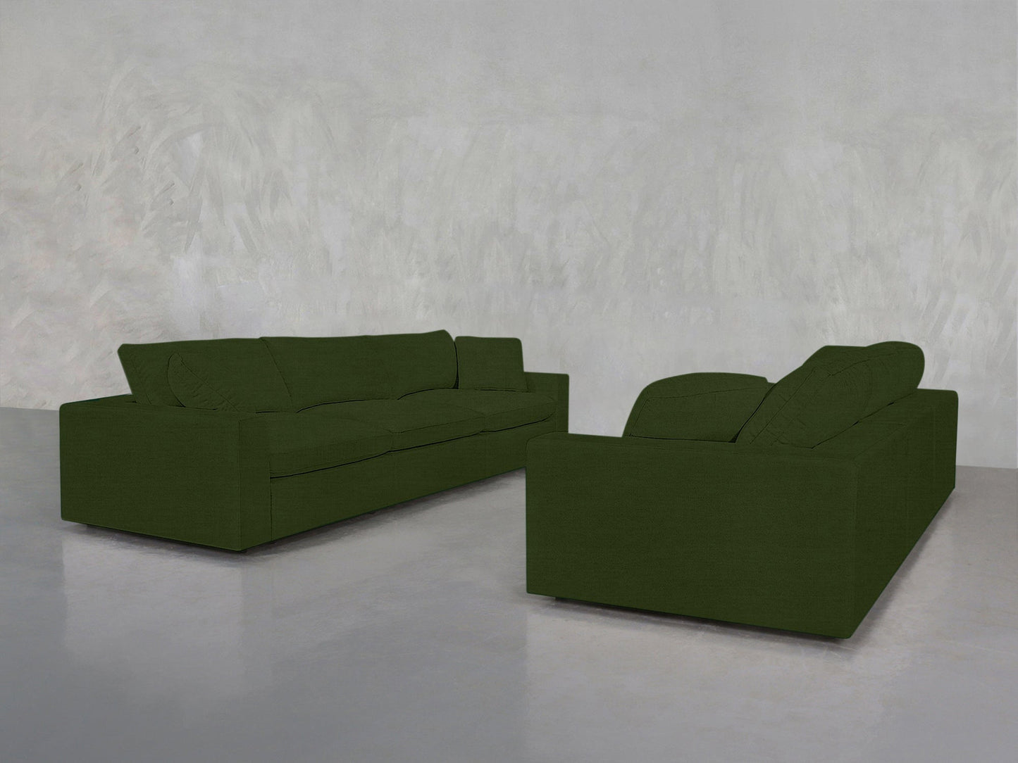 A pair of modern 3-3 Sofa Set pieces in dark green with clean lines are arranged in an L-shape on a polished concrete floor beside a light grey textured wall.
