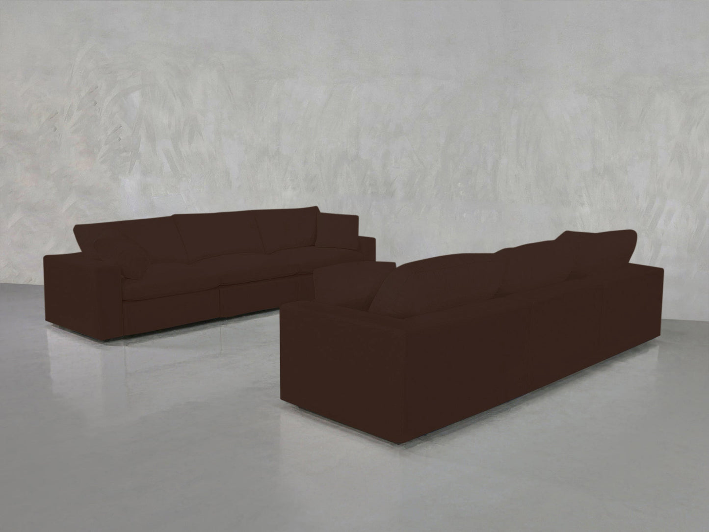 The 3-3 Sofa Set in dark brown is arranged L-shaped on a shiny, light gray floor against a textured, light gray wall in a minimalist room.