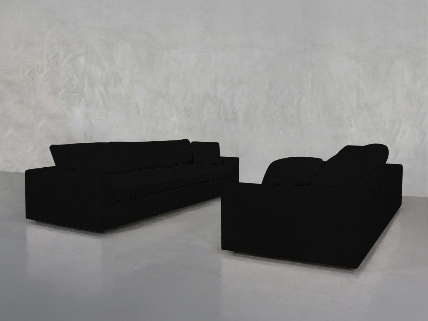 A pair of 3-3 Sofa Sets in modern black are arranged facing each other in a minimalist room featuring light gray textured walls and a glossy light gray floor.