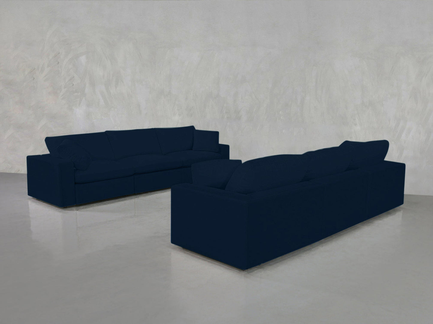 Two 3-3 Sofa Sets in dark blue are arranged facing each other in a minimalist room with light gray textured walls and a shiny light floor, creating a simple, modern look.
