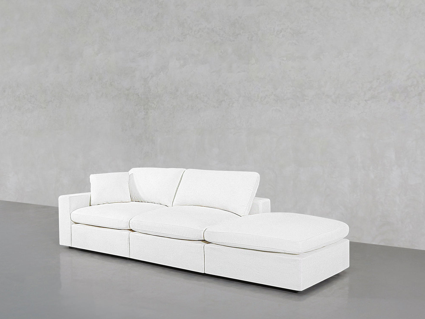 The 3-Seat Modular Lounger Sofa in modern white features a right-side chaise, set against a plain light gray textured wall and floor.