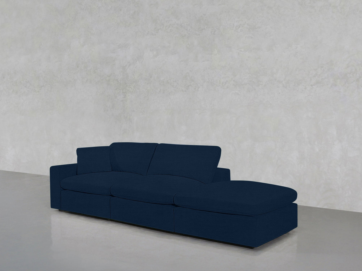 The 3-Seat Modular Lounger Sofa, in modern dark blue with a right-side chaise, is set against a plain light gray wall and floor.