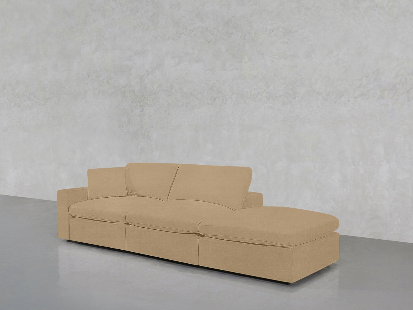A 3-Seat Modular Lounger Sofa in beige with a right-side chaise sits on a polished gray floor against a light gray textured wall.