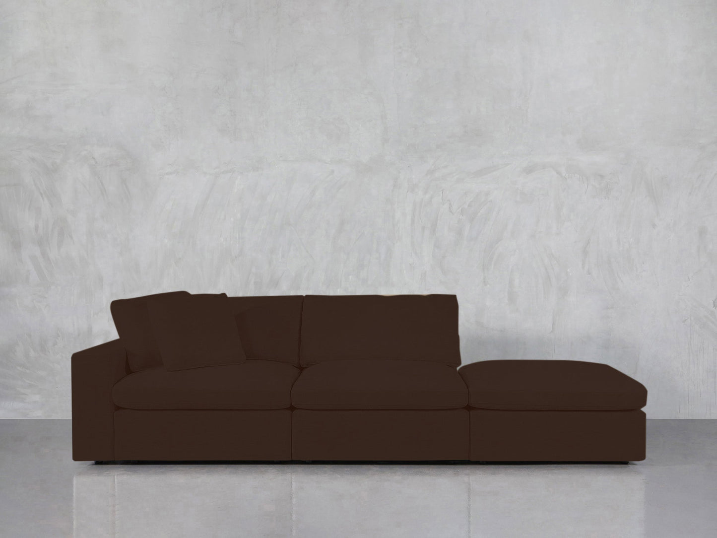 A 3-Seat Modular Lounger Sofa with a dark brown finish and right-side chaise is placed against a light gray textured wall on a reflective floor.