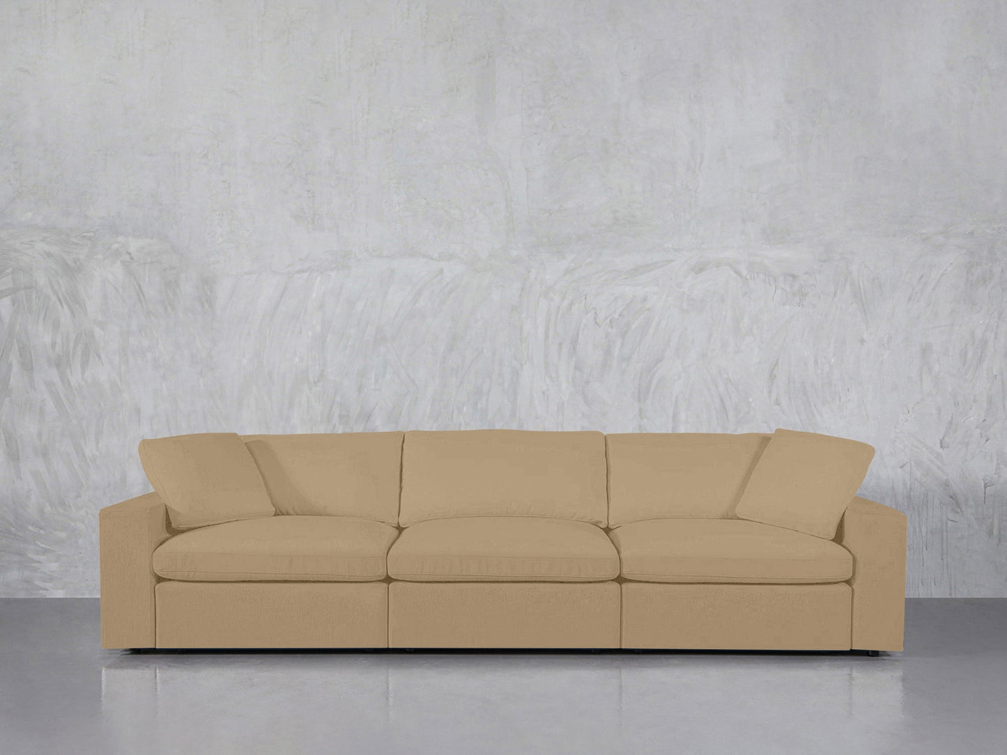 A 3-Seat Modular Sofa in beige with clean lines is set against a light gray textured wall on a reflective gray floor.