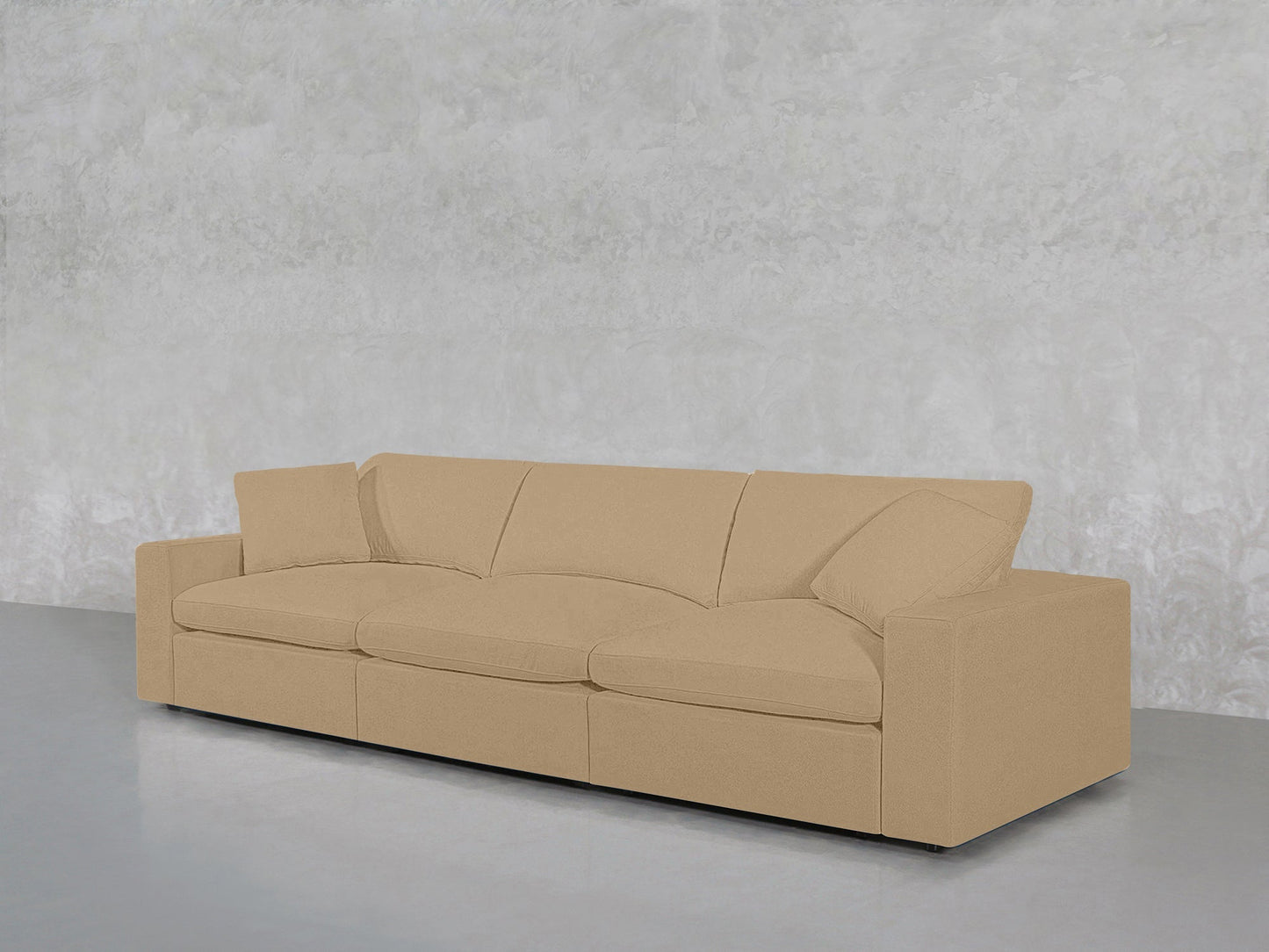 The 3-Seat Modular Sofa, in beige with straight arms and three seat cushions, is placed against a light gray textured wall on a smooth gray floor.