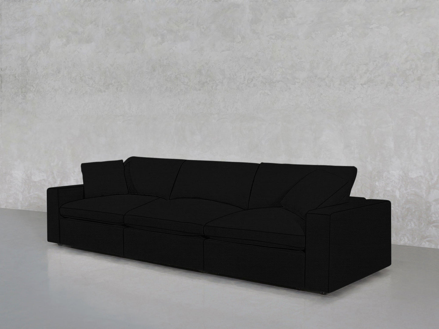 A 3-Seat Modular Sofa with firm cushions and straight armrests in black stands against a light grey textured wall atop a smooth, pale floor.