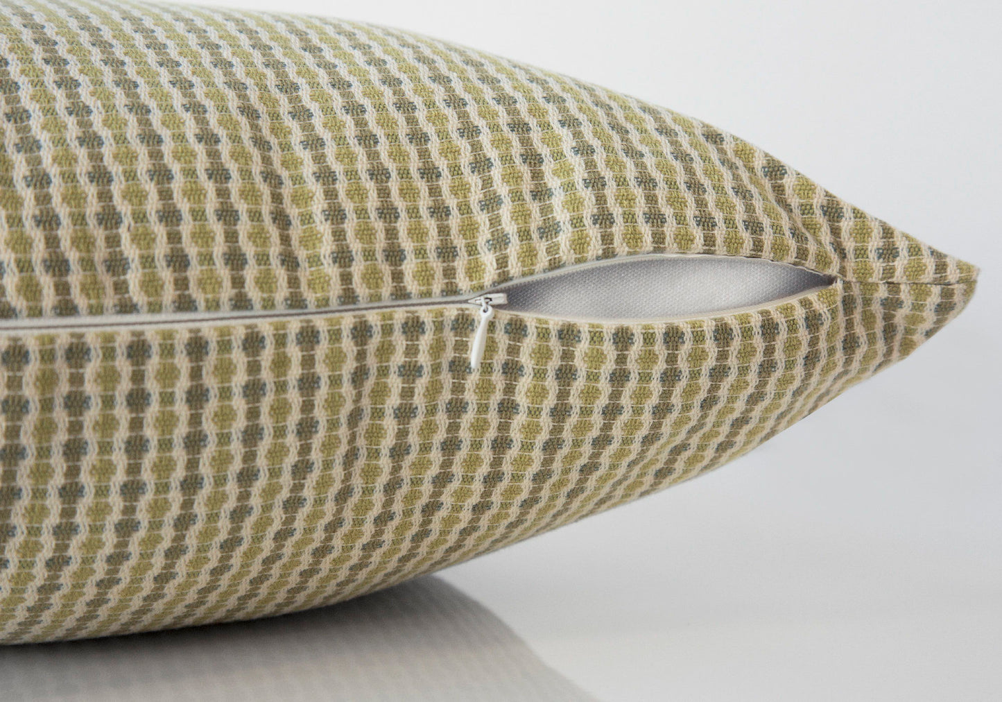 Close-up of a Square Decorative Throw Pillow (insert included) with a green and beige checkered pattern and partially open white zipper, hypoallergenic design, shown against a plain white background.