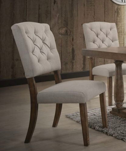 Two Bernard - Weathered Side Chairs with tufted backs and wooden legs sit beside a wooden dining table on a light-colored rug in a room featuring wooden walls and flooring.