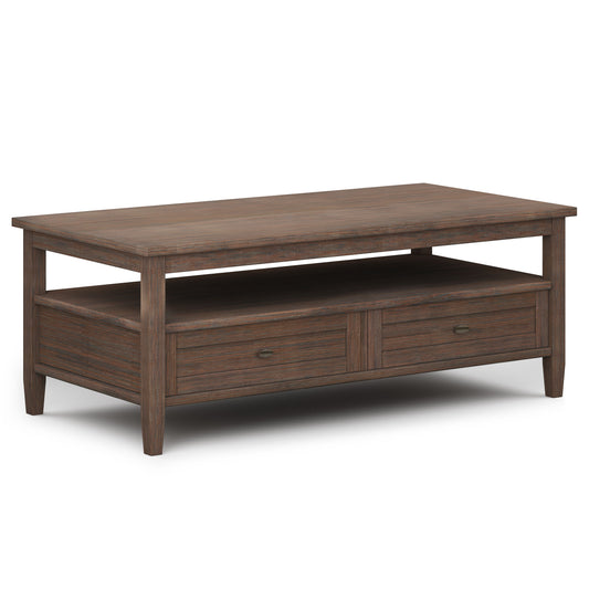 The Warm Shaker Coffee Table in Farmhouse Brown features a rectangular top, open shelf, two lower drawers, a dark brown finish, and tapered legs.