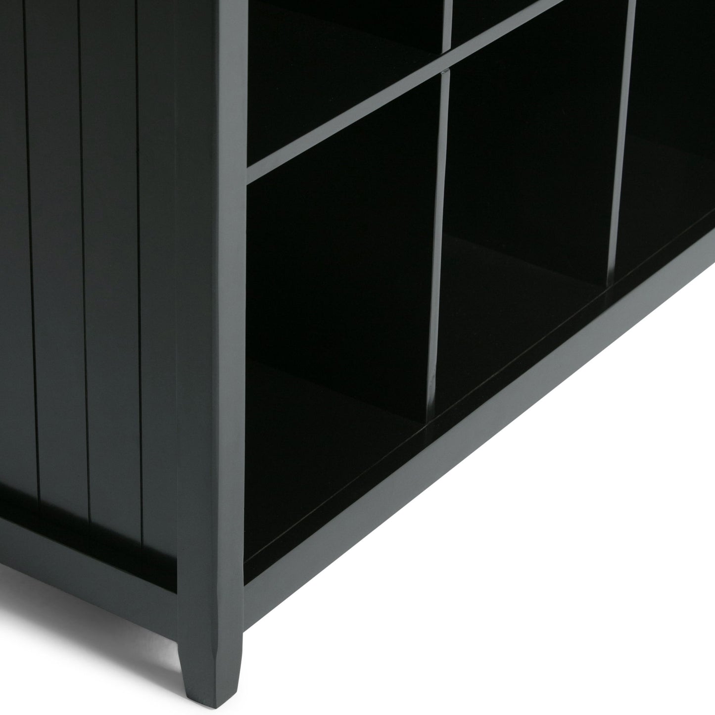 Close-up of the Acadian - Handcrafted Cube Storage, a black wooden shelf featuring six square cubby compartments, viewed from a low side angle against a white background.