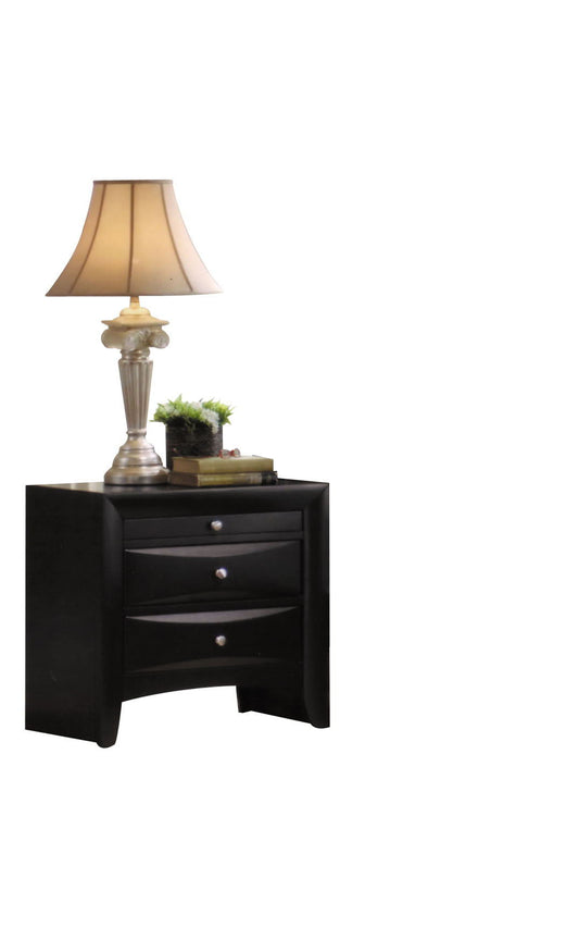The Ireland - Elegant Design Nightstand features three black drawers with silver knobs, and is styled with a classic beige lamp, stacked books, and a small potted plant against a plain white backdrop.