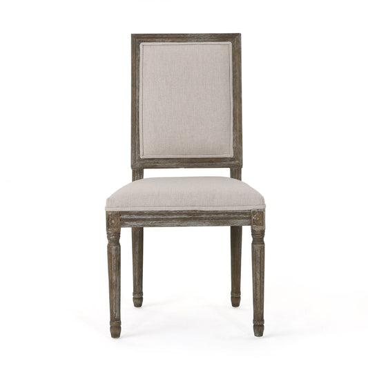 Front view of the Traditional Style Dining Chair Set With Fabric Upholstery featuring a rectangular, padded beige fabric seat and backrest, carved leg detailing, and weathered wood finish.