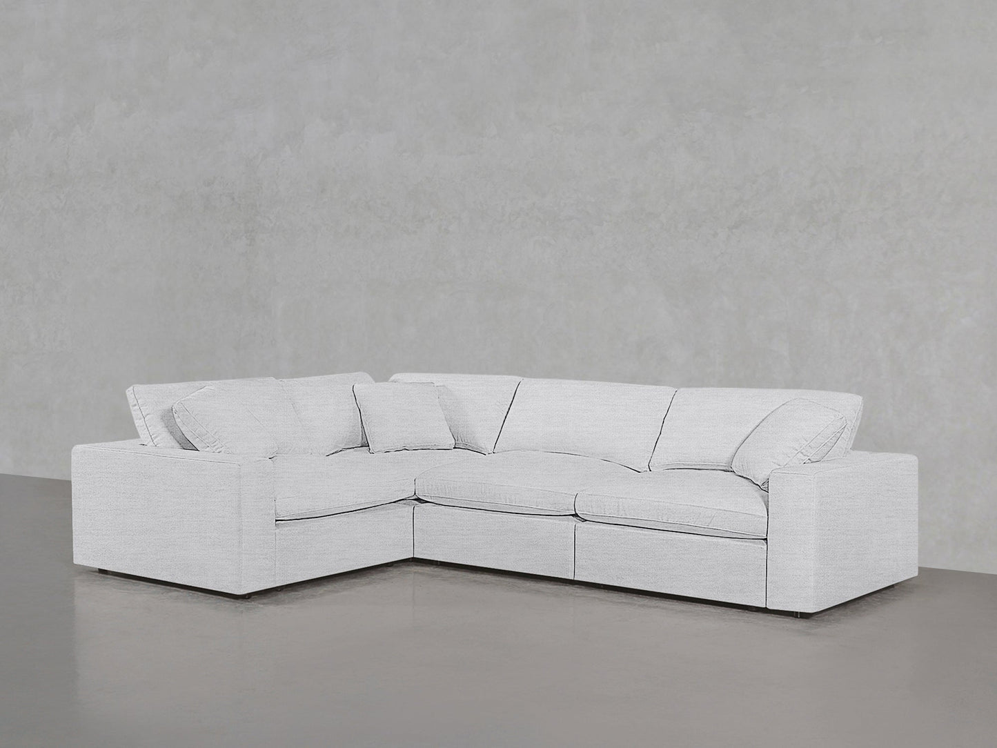 A 4-Seat Modular Corner Sectional in light gray with clean lines and plush cushions sits against a matching plain wall and floor in a minimalist setting.