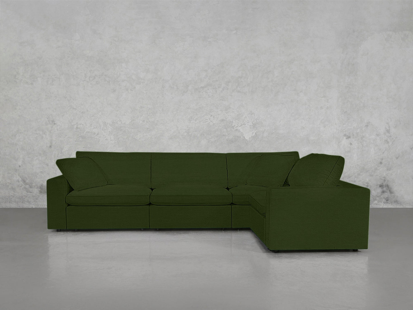A 4-Seat Modular Corner Sectional with clean lines in green sits on a glossy light gray floor against a textured gray wall.