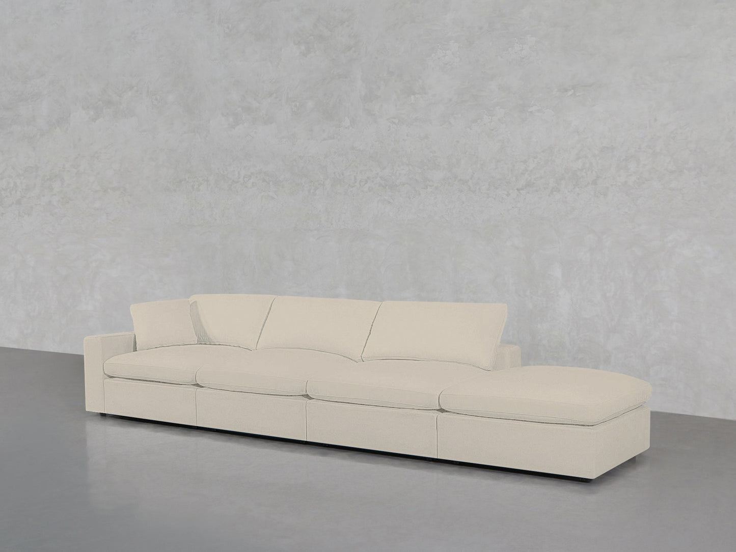 The 4-Seat Modular Lounger Sofa in light beige features four seat cushions and a right-side chaise, set against a textured light gray wall on a smooth gray floor.