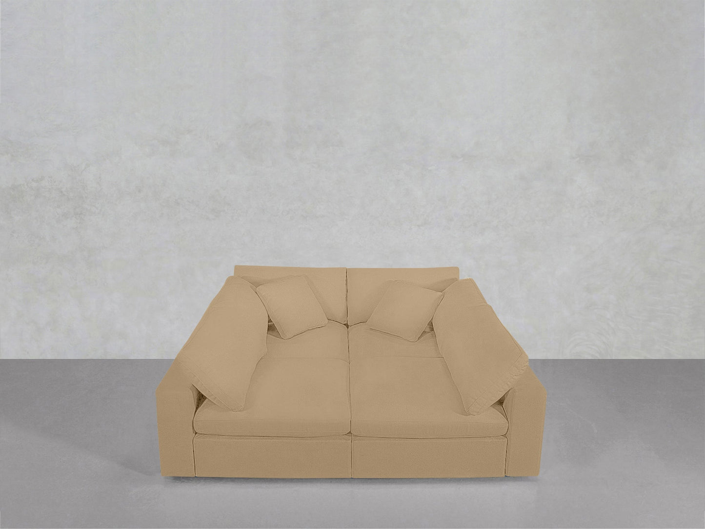 A beige, modern 4-Seat Modular Pit with wide arms and two matching cushions sits on a gray floor against a light gray textured wall.