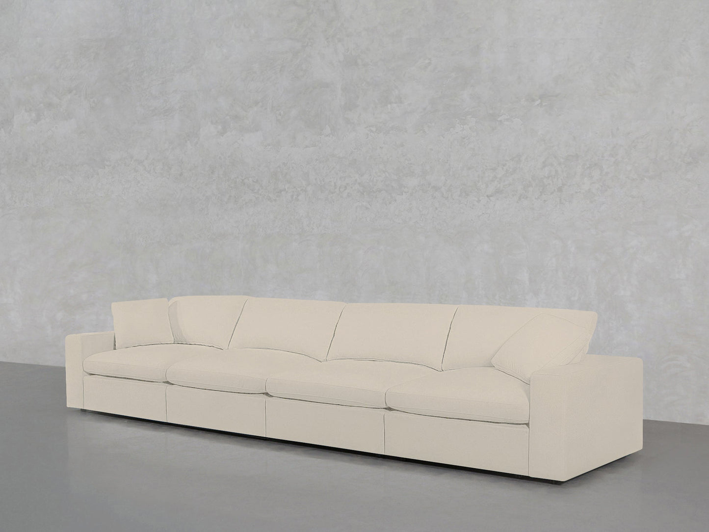 A 4-Seat Modular Sofa in cream is positioned against a light gray textured wall on a smooth gray floor.