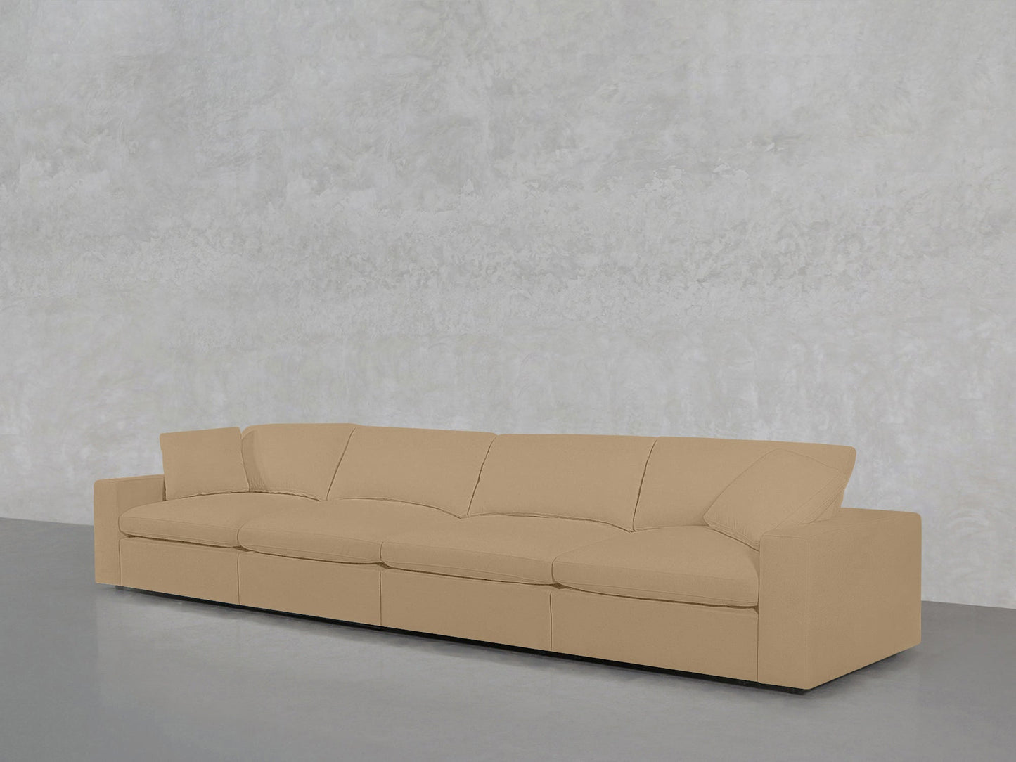 The 4-Seat Modular Sofa, beige and modern with four seat and back cushions, is placed against a light gray textured wall on a gray floor.