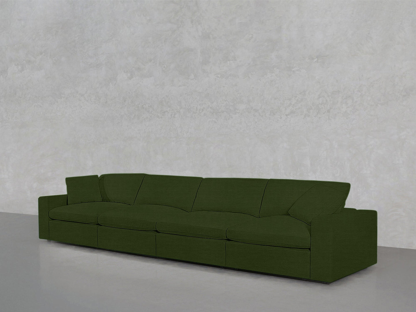 A 4-Seat Modular Sofa with modern green upholstery and clean lines sits against a light gray textured wall on a smooth gray floor.