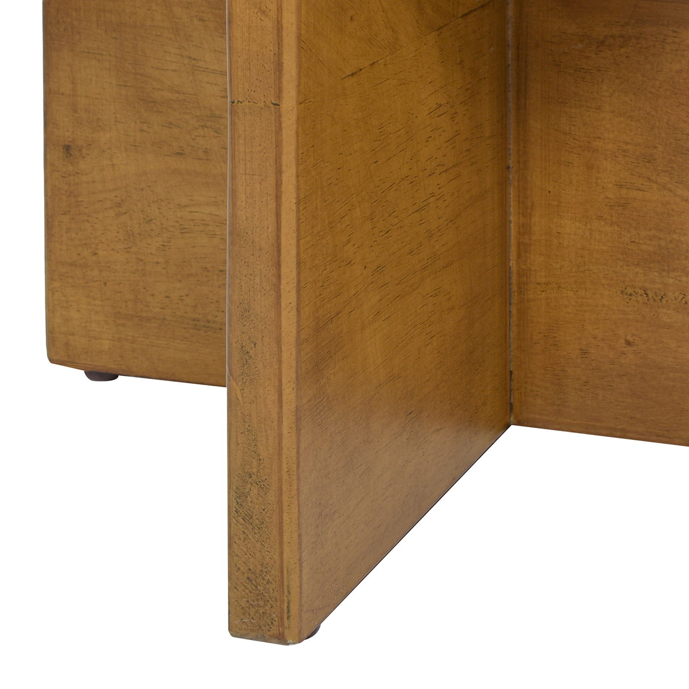 Close-up view of the corner and legs of the Bali - Round Upholstered Ottoman, highlighting its natural wood grain and construction details.