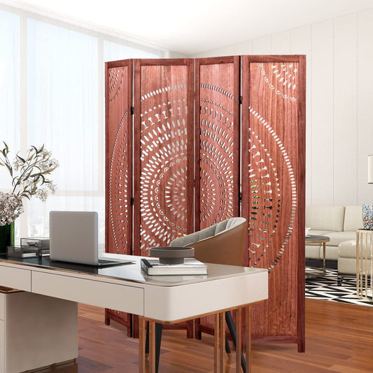 A modern home office with a white desk, laptop, and brown chair is separated from the living room by a Panel Solid Wood Folding Room Divider featuring intricate circular cut-out patterns.